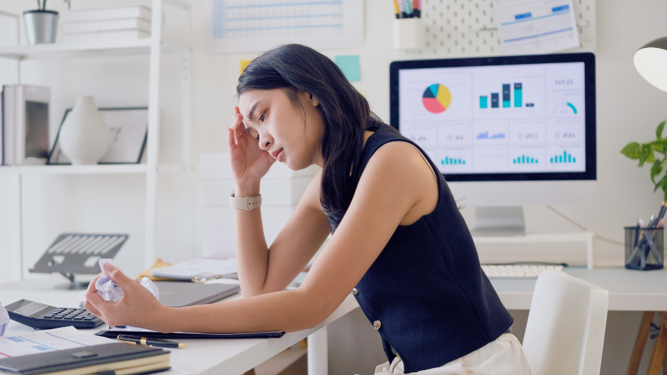 woman sitting at desk looking frustrated