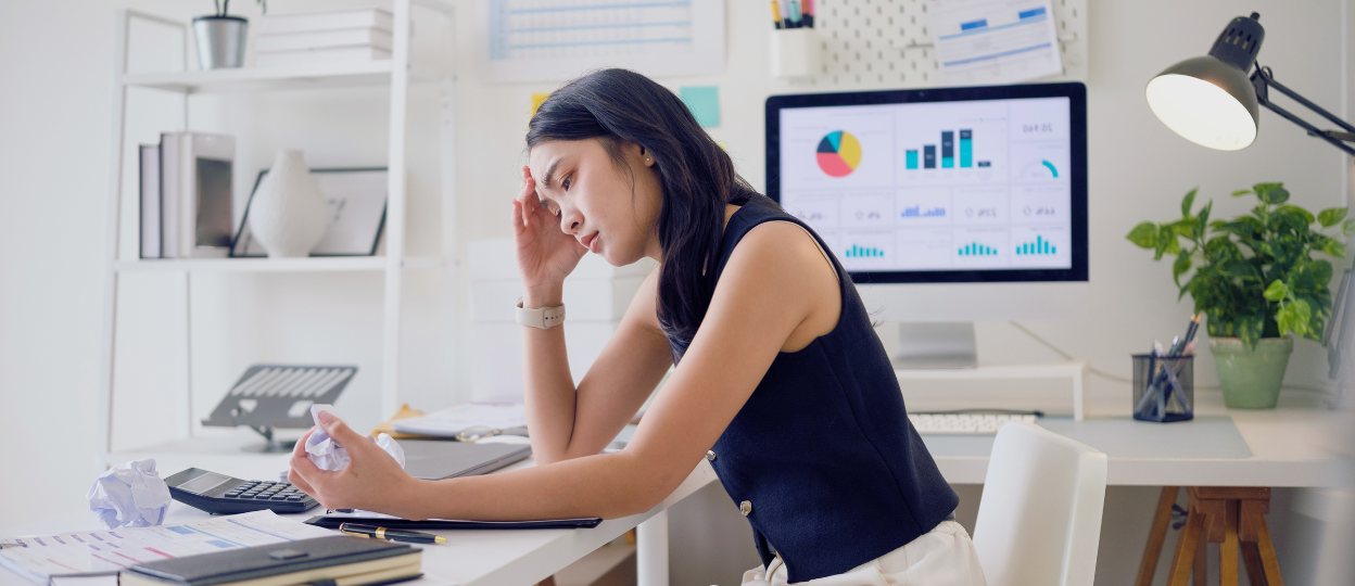woman sitting at desk looking frustrated